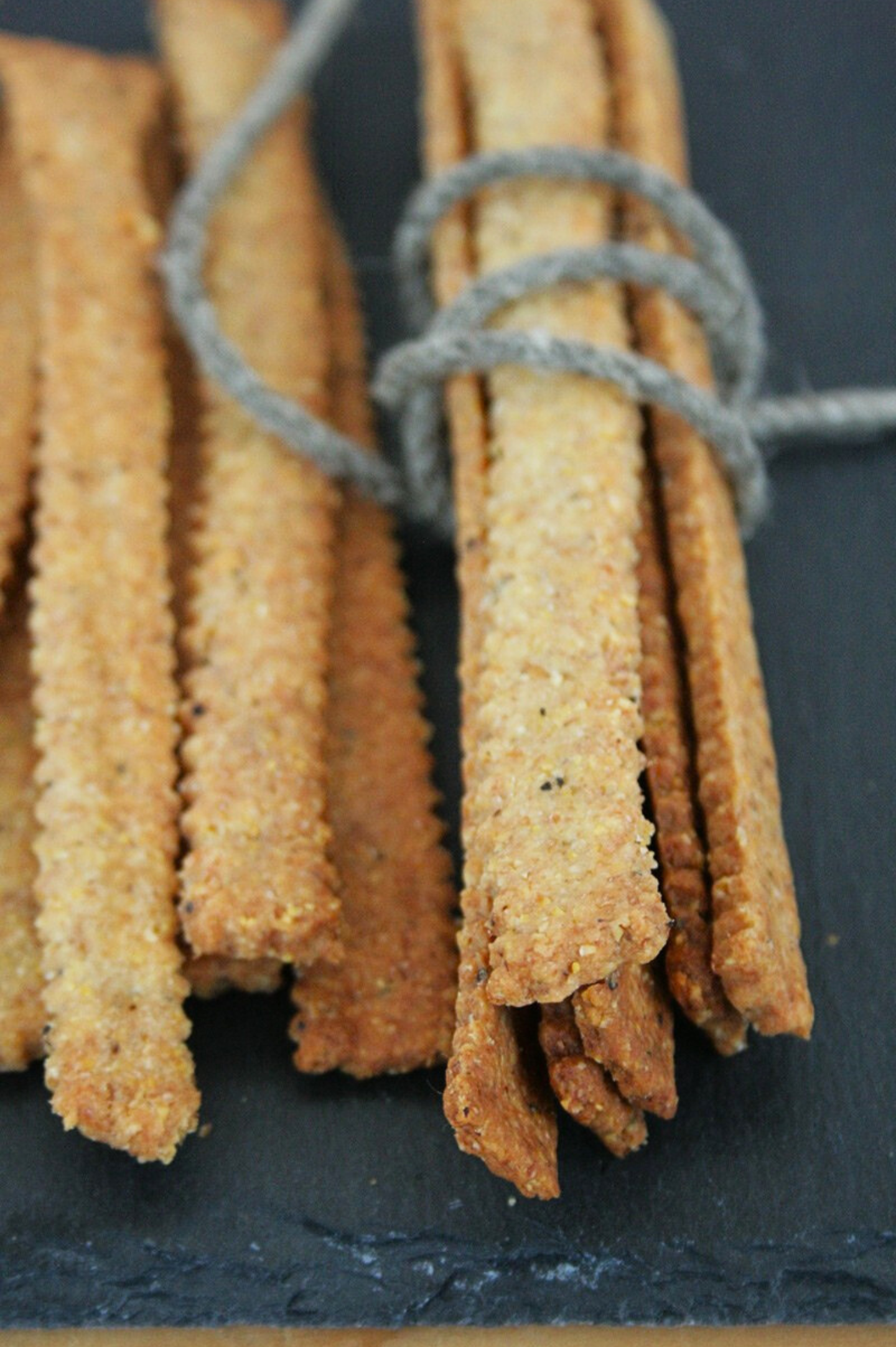 Grissini cacio e pepe vegani, croccanti e rustici, preparati con farine miste e formaggio vegetale alla frutta secca.